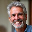 A smiling middle-aged man with a warm expression.