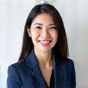 A professional woman in business attire, smiling confidently.