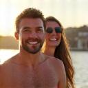 A happy couple in their 40s in a sunny coastal town.